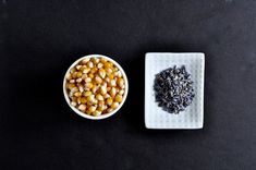 two bowls filled with different types of food on top of a black surface next to each other