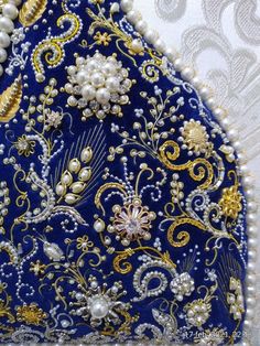 a blue and gold purse with pearls on it