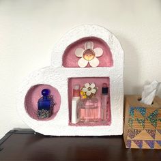 a shelf with some bottles on it next to a tissue paper box and an ornament