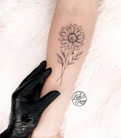 a woman's arm with a sunflower tattoo on it