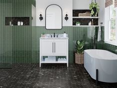 a bathroom with green tiles and a white bathtub in the corner next to a window