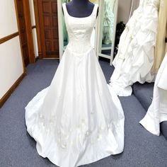 a white wedding dress on display in a bridal room