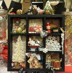 a display case filled with lots of christmas decorations and ornaments on top of a table