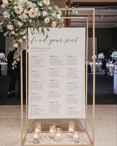 a wedding seating chart with candles and flowers on the table for guests to sit at