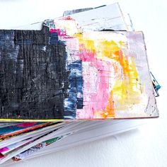 a stack of magazines sitting on top of each other next to a white tablecloth