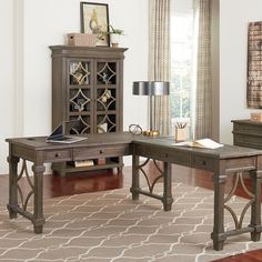 a wooden desk sitting on top of a hard wood floor next to a book shelf