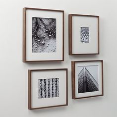 three framed photographs hang on the wall next to each other, one with raindrops