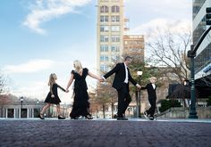 a family in formal wear walks across a cross walk in downtown Asheville Family Pics In The City, Family Photo Downtown, City Family Pictures, Downtown Family Session, Downtown Photoshoot Family, Goofy Photoshoot, Winter Photo Outfits, Formal Family Photoshoot, Downtown Family Photoshoot