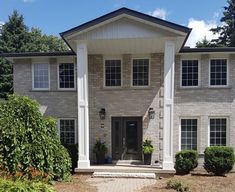 a large house with white trim and black shutters on the front door is shown