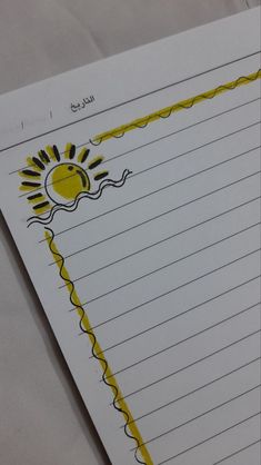 a piece of lined paper with an image of a sun and clouds on the side