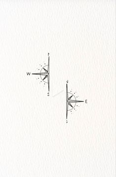 two compasss are drawn on paper with one pointing to the opposite direction and the other pointing