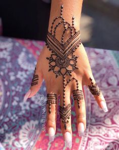 a woman's hand with henna tattoos on it