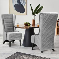 a dining room table with two chairs and a rug on the floor