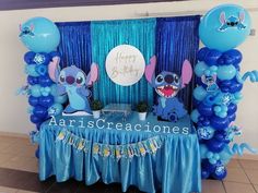 a table with blue balloons and decorations for a birthday party or baby's first birthday