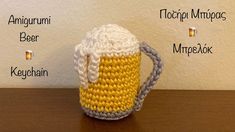 a crocheted beer mug sitting on top of a table next to a wall