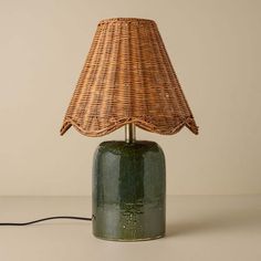 a green lamp with a wicker shade on it