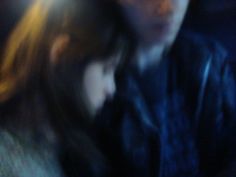 blurry photograph of man and woman on cell phone