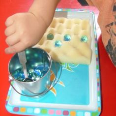 a small child is eating waffles on a tray with a cup of water