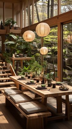 a wooden table with benches and lights hanging from it's sides in front of large windows