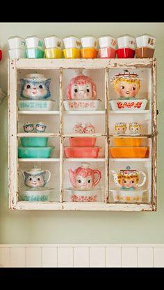 an old window is filled with dishes and cups on display in the corner of a kitchen