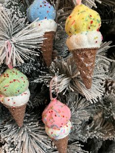 three ice cream cones are hanging from a christmas tree with sprinkles on them