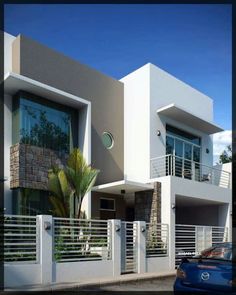 a car parked in front of a white building with balconies on the windows