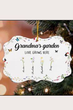 an ornament hanging from a christmas tree that says grandma's garden love grows here