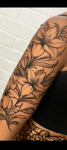 a woman's arm with black and white flowers on the left side of her body