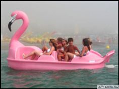 a group of people riding on top of a pink boat