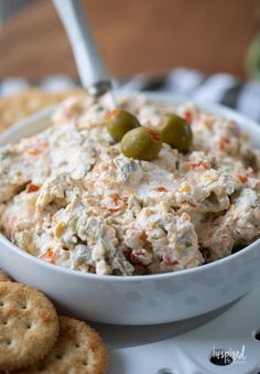 a white bowl filled with food next to crackers