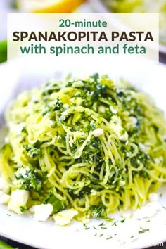 spaghetti with spinach and feta on a white plate