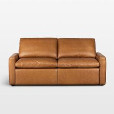 a brown leather couch sitting on top of a white floor