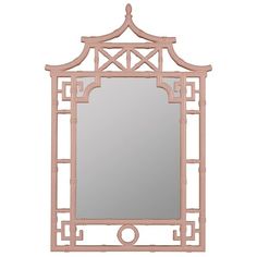 a mirror that is sitting on top of a table with a light pink frame around it