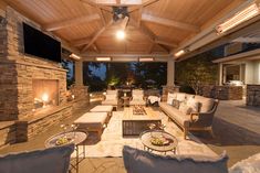 an outdoor living area with couches and fireplace