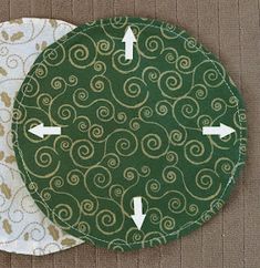 two circular coasters with arrows pointing to each other on a brown tablecloth background