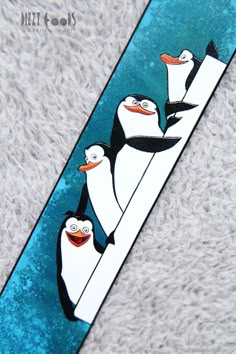 three penguins are standing on top of a surfboard