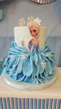 a frozen princess cake with blue frosting and snowflakes on it's sides