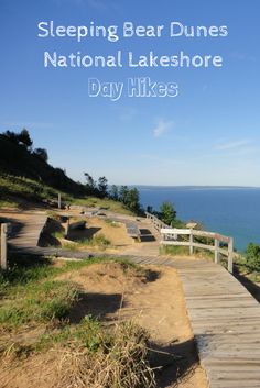 there is a wooden walkway leading to the beach and water with benches on it, along with text reading sleeping bear dunes national lakes day hikes