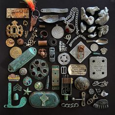 an assortment of antique and modern items on a black table top, including metal objects