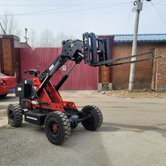 a red forklift parked in front of a building