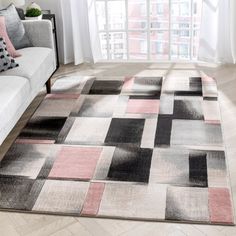 a living room area with a couch, chair and rug in front of a window