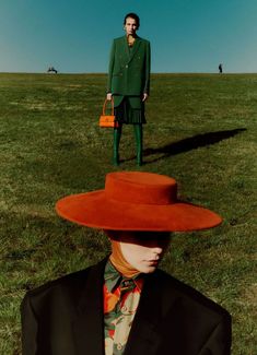 a man in a green suit and red hat standing on top of a grass covered field