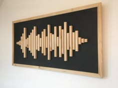 a sound board mounted to the wall with wooden sticks in it's center and an equalizer on top