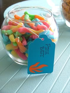 a glass bowl filled with colorful candy and a blue tag on the top that says pet sit