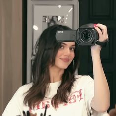 a woman holding up a projector in front of her face while she is taking a selfie