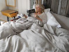 a woman laying in bed reading a book