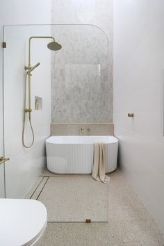 a white bath tub sitting next to a walk in shower