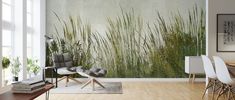 a living room with a table and chairs in front of a wall mural that has grass growing on it