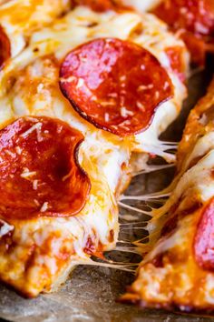 slices of pepperoni pizza sitting on top of a pan