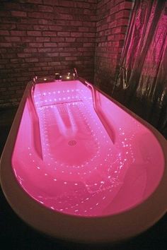 a pink bath tub sitting next to a brick wall